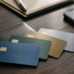 Vier verschiedenfarbige Kreditkarten neben Geldbörse und Smartphone
