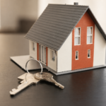 Hausmodell und Schlüssel als Symbol für Immobilienverwaltung